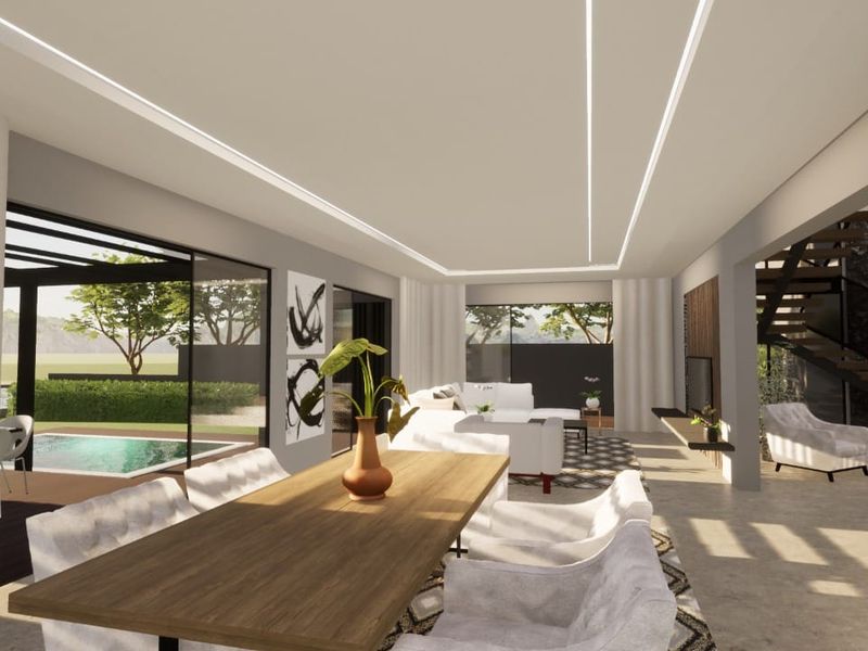 Spacious open-plan living and dining area featuring modern recessed linear lighting, large sliding glass doors, and a striking stone feature wall with staircase.