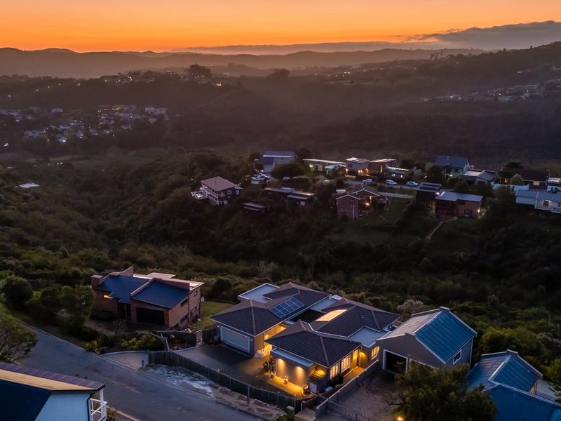 Aerial view of a residential property at sunset, showcasing the roof structure, solar panels, and surrounding neighbourhood landscape.