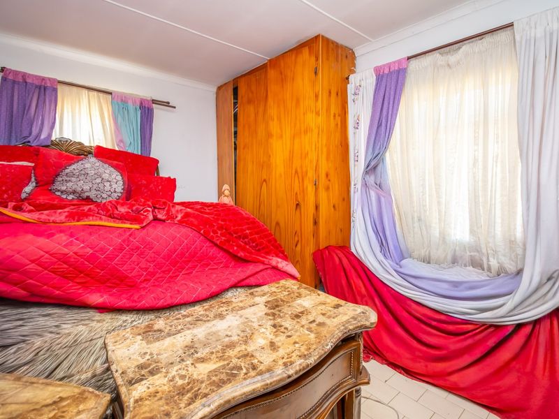 A bedroom featuring built-in wooden cabinetry and tiled flooring, offering a functional space with potential for modern updates.