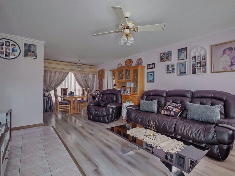Open plan living and dining area featuring a combination of laminate and tiled flooring, tongue and groove ceiling, and dual ceiling fans.