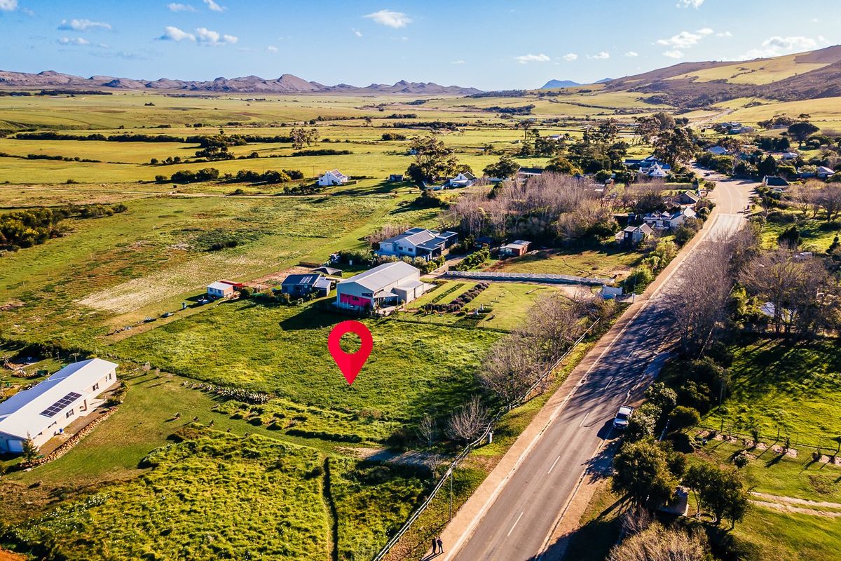Aerial view of a vacant residential land plot situated in a rural landscape with direct road access and surrounding countryside views.