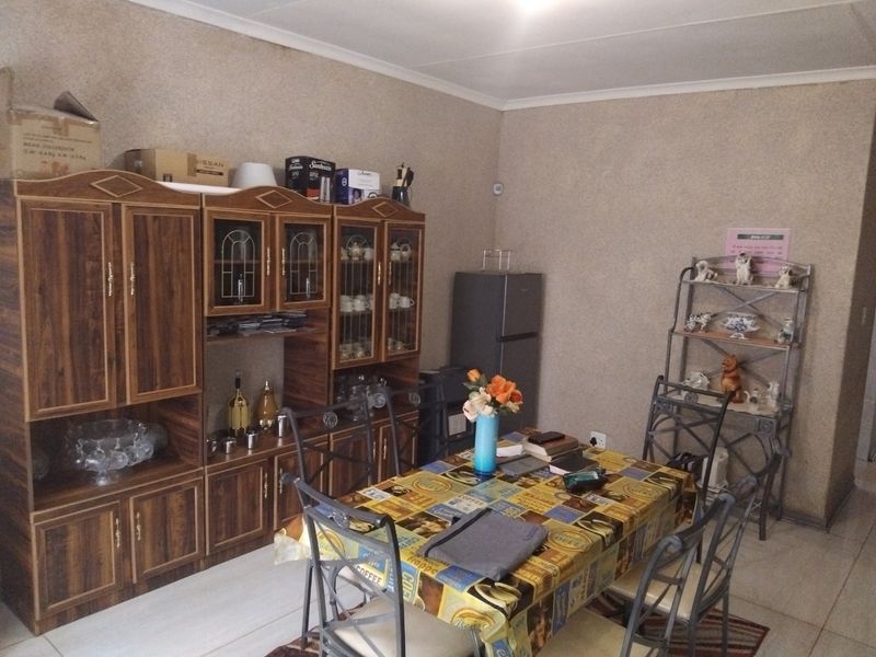 A functional dining area featuring tiled flooring and coved ceiling details, providing a practical space for family meals.