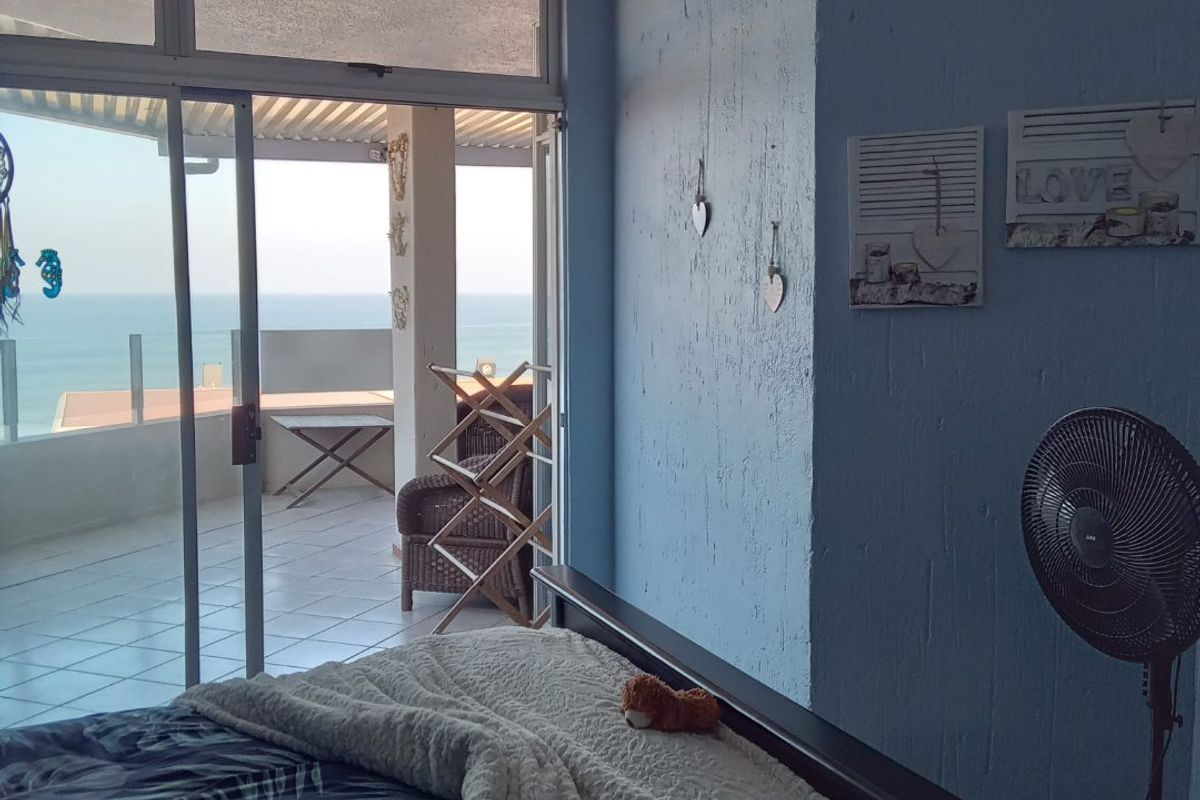 Bedroom featuring a sliding glass door that opens onto a balcony with ocean views.