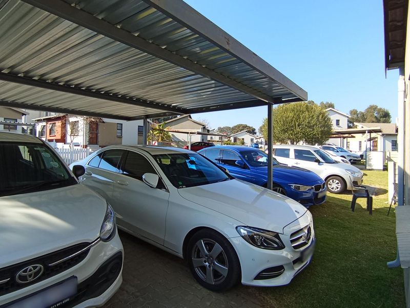 A covered carport area providing sheltered parking space for multiple vehicles.