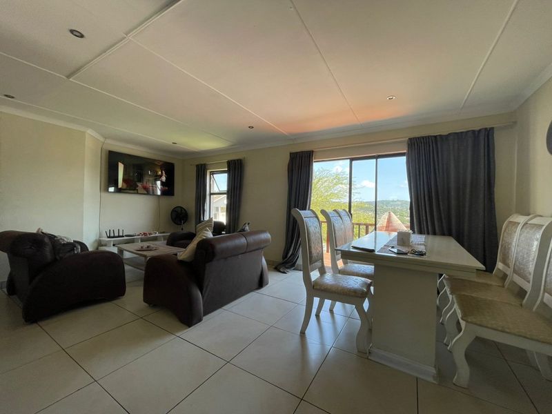 Spacious open-plan living and dining area featuring large format floor tiles, recessed lighting, and sliding glass doors leading to an outdoor space.