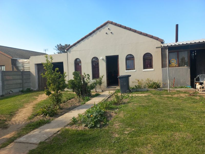 Front elevation of a single-story house featuring a tiled roof, arched windows, and a concrete walkway leading to the entrance.