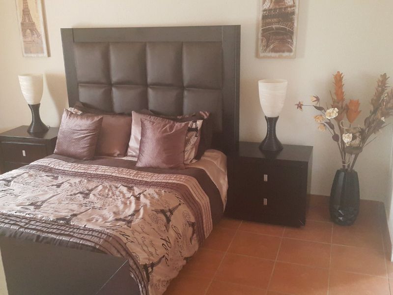 A bedroom featuring tiled flooring and neutral wall finishes.