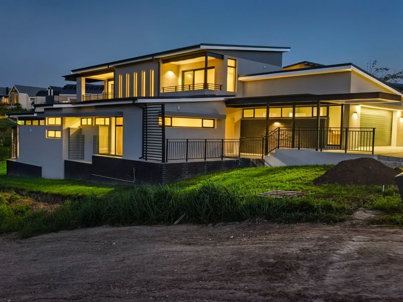 Modern multi-level residential property at dusk, featuring contemporary architectural design, integrated balcony, garage, and exterior lighting.