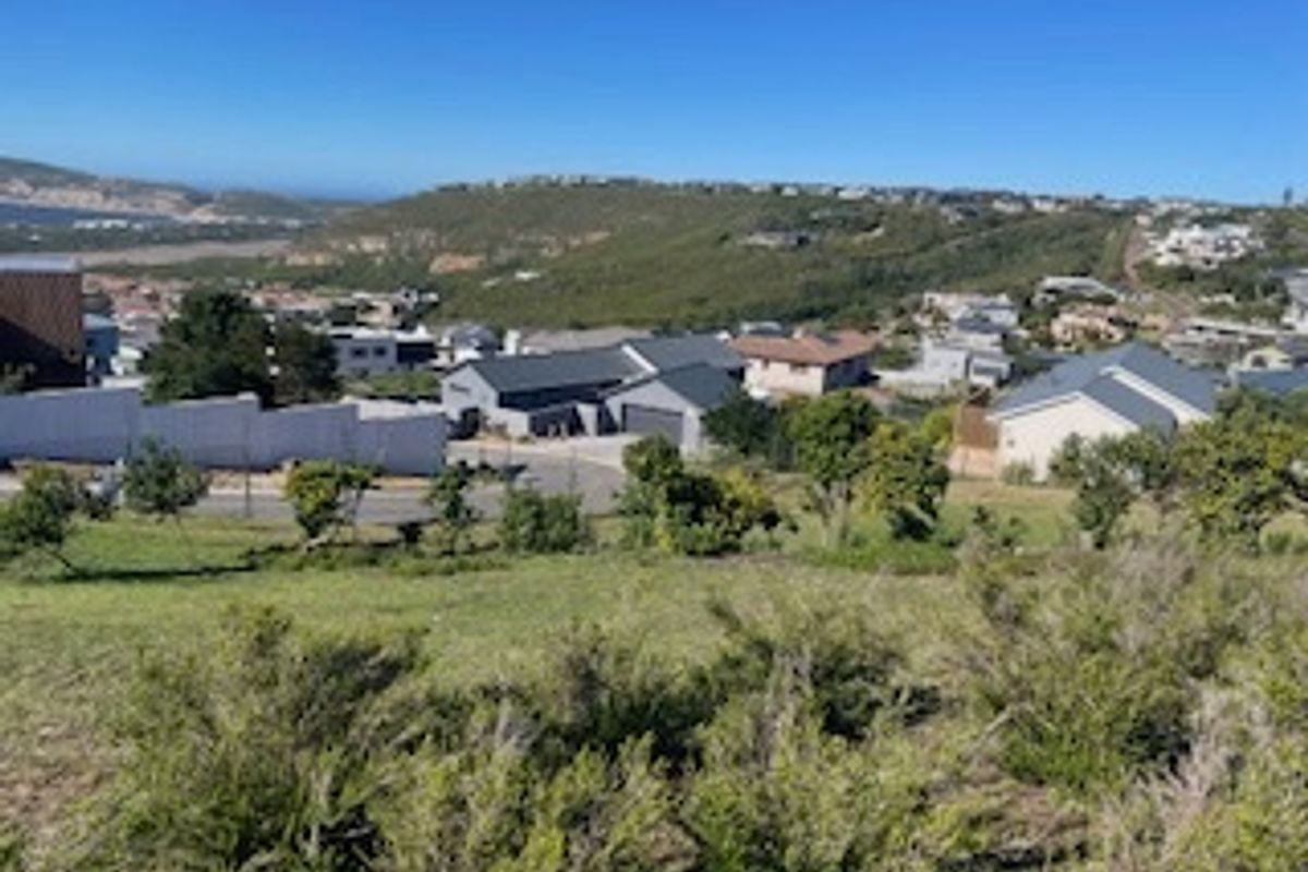 Elevated view overlooking a residential neighborhood and surrounding landscape from a vacant residential plot.
