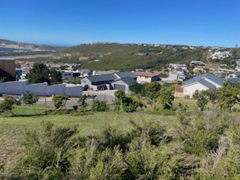Elevated view overlooking a residential neighborhood and surrounding landscape from a vacant residential plot.