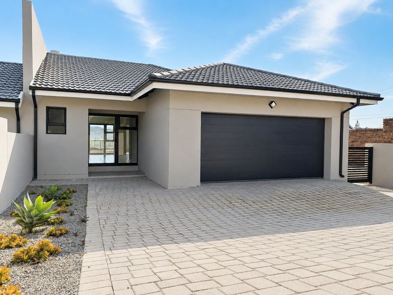 Modern front elevation featuring a paved driveway, automated garage door, and clean architectural lines with a well-maintained tiled roof.