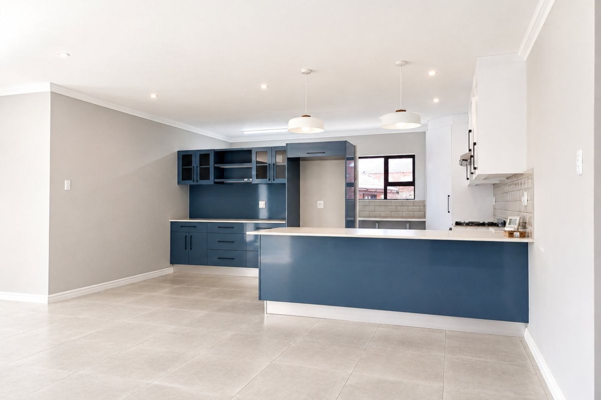Modern, open-plan kitchen featuring blue cabinetry, a central island, tiled backsplash, and contemporary pendant lighting in a bright, neutral space.