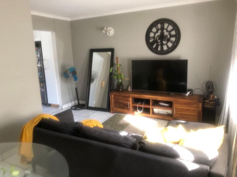 A living room area featuring tiled flooring and neutral wall paint, providing a functional space for relaxation and entertainment.