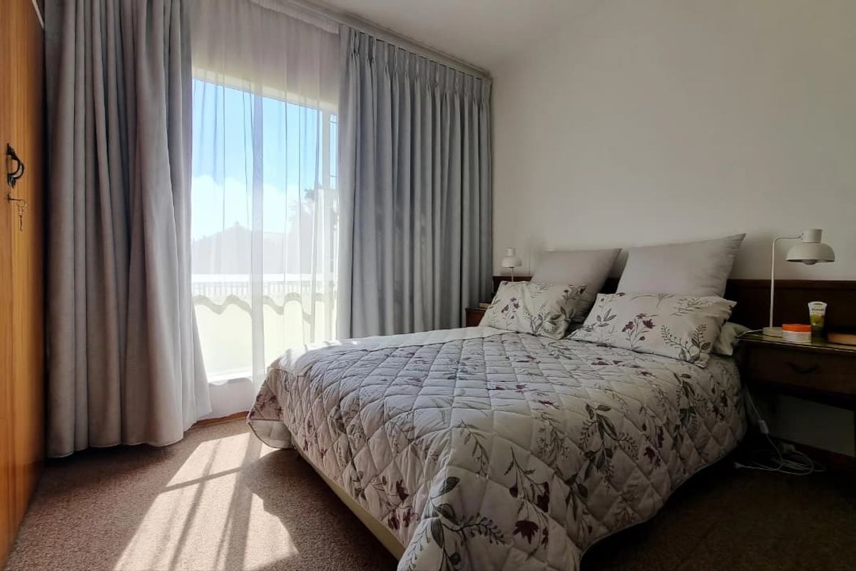 A bedroom featuring carpet flooring, a built-in wardrobe, and a sliding glass door providing access to an outdoor area.
