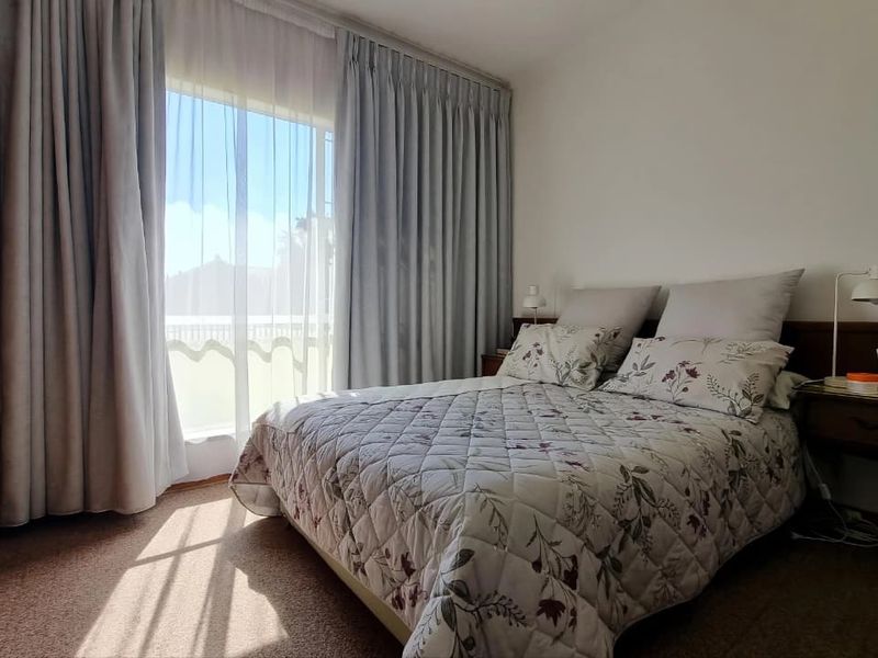 A bedroom featuring carpet flooring, a built-in wardrobe, and a sliding glass door providing access to an outdoor area.