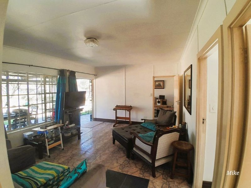 A living room area featuring tiled flooring, a ceiling light fixture, and a sliding glass door providing access to an outdoor space.