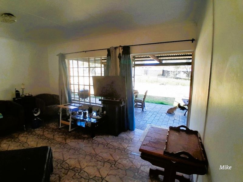 Living room area featuring tiled flooring and direct access to an outdoor patio through a sliding door.