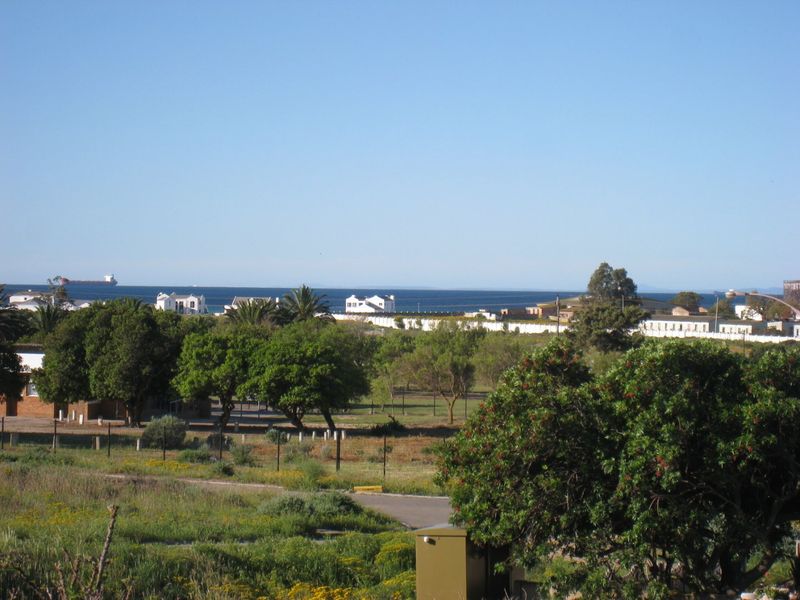A scenic landscape view overlooking the surrounding residential area with a distant ocean horizon and clear blue sky.