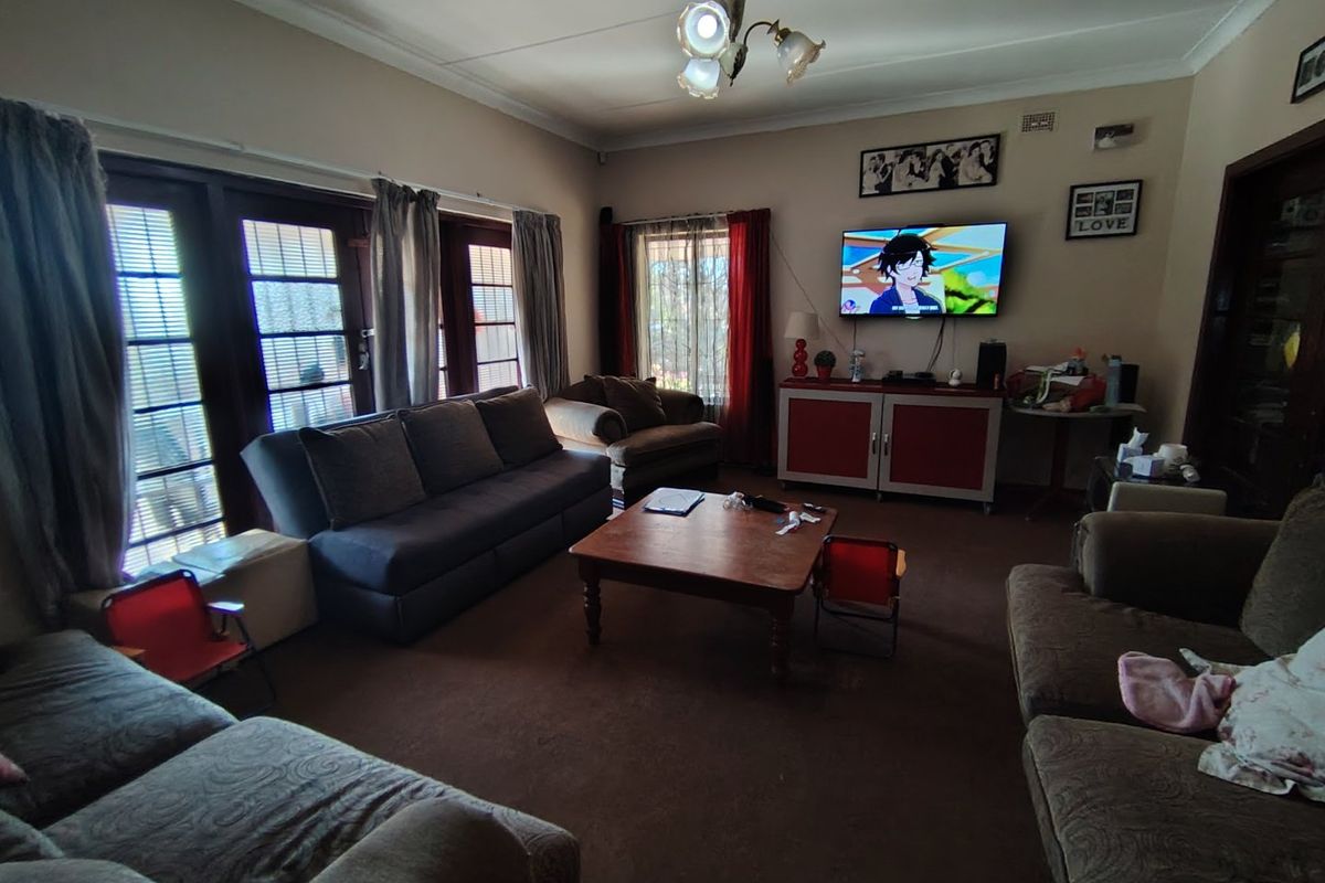 A spacious living room featuring classic french doors that provide natural light and access to the exterior, complemented by traditional ceiling coving.