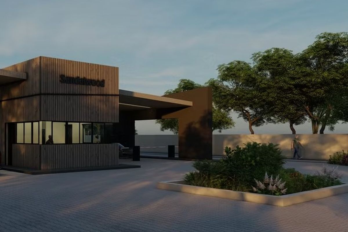 Modern security gatehouse entrance for Sandalwood estate featuring contemporary timber-slat cladding, paved driveway, and landscaped garden beds.