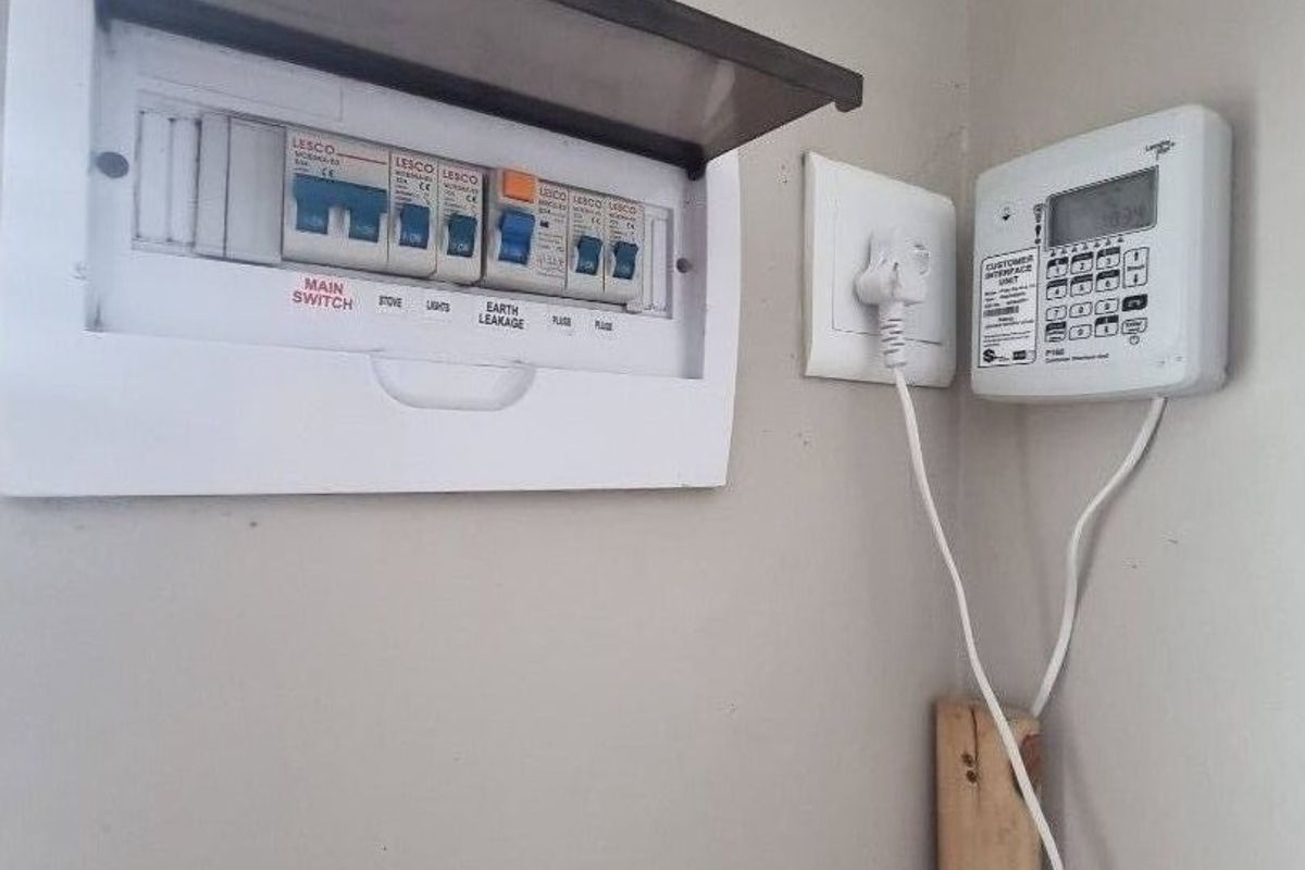 A utility wall featuring a standard electrical distribution board and a prepaid electricity meter interface unit.