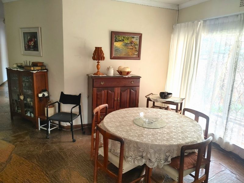 A dining area featuring natural stone flooring and a large sliding glass door that provides ample natural light.