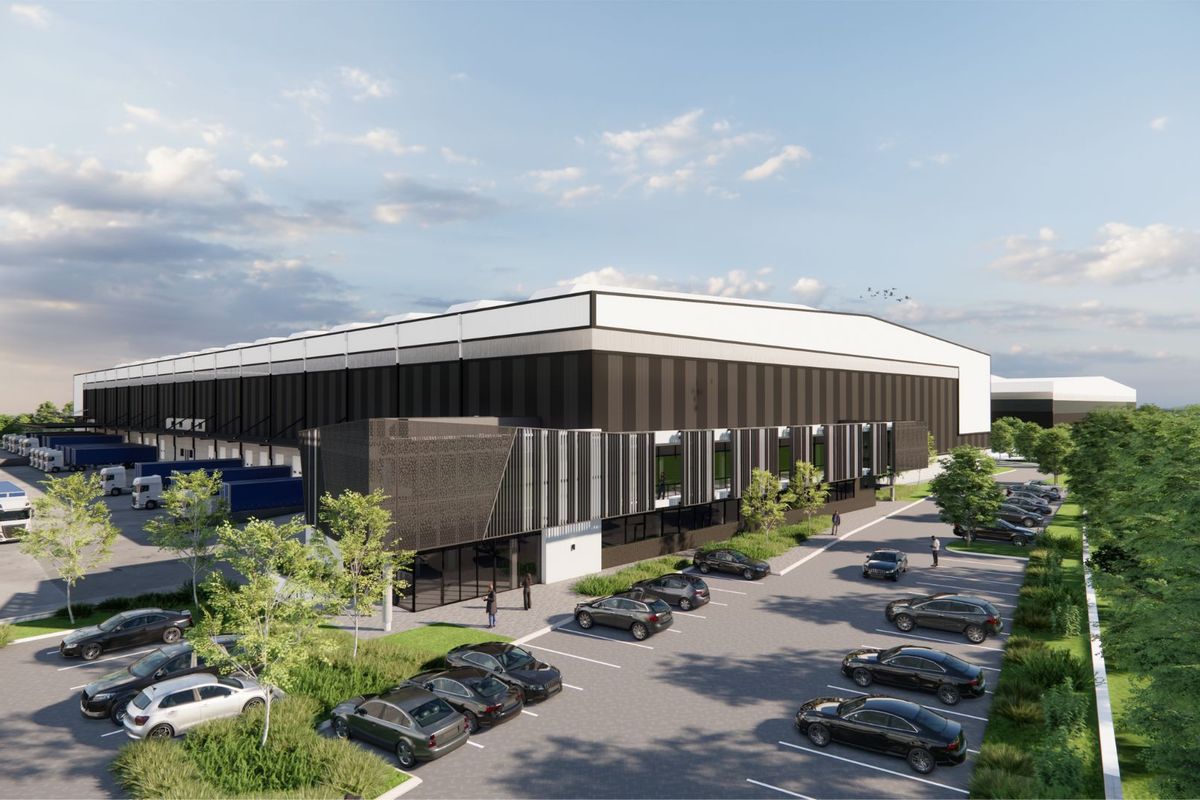 An aerial perspective of a modern industrial warehouse facility featuring extensive loading docks, dedicated parking areas, and professional landscaping.