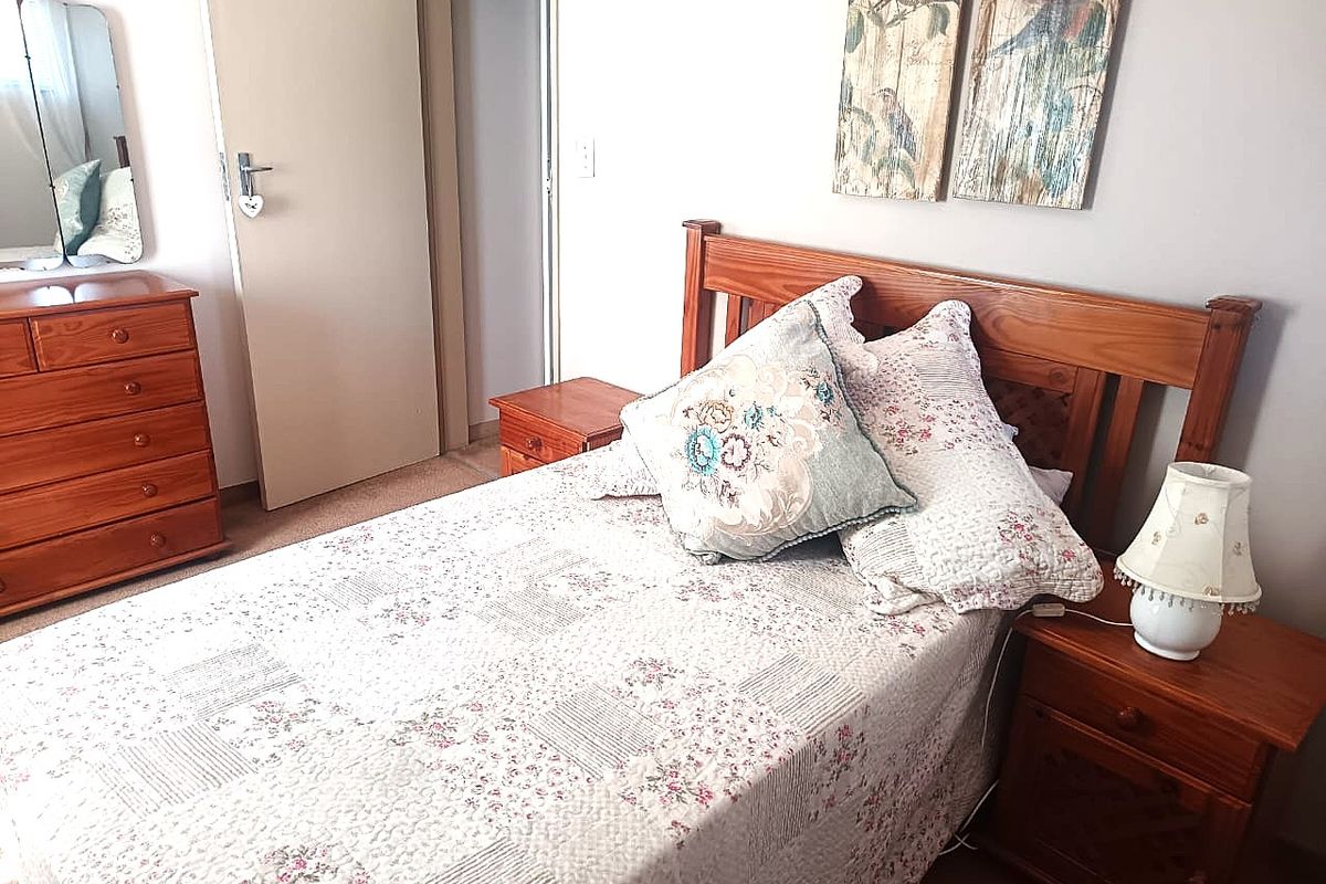 A functional bedroom featuring carpeted flooring and neutral wall finishes, providing a comfortable and well-maintained living space.