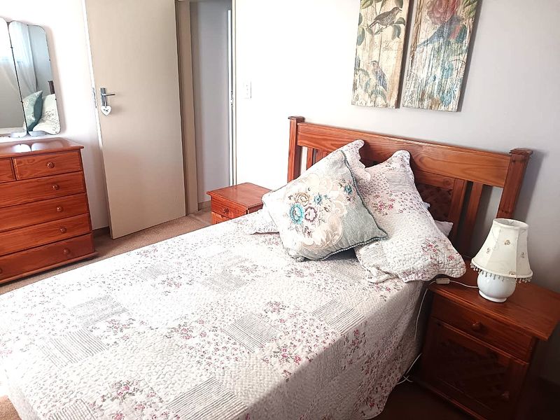 A functional bedroom featuring carpeted flooring and neutral wall finishes, providing a comfortable and well-maintained living space.
