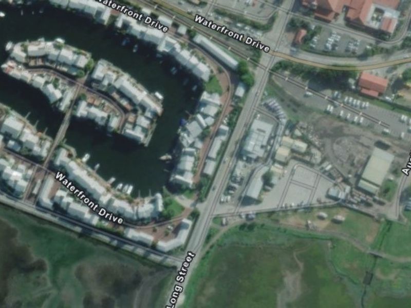 Aerial view of the commercial property location, highlighting its proximity to the waterfront, marina, and local road infrastructure.