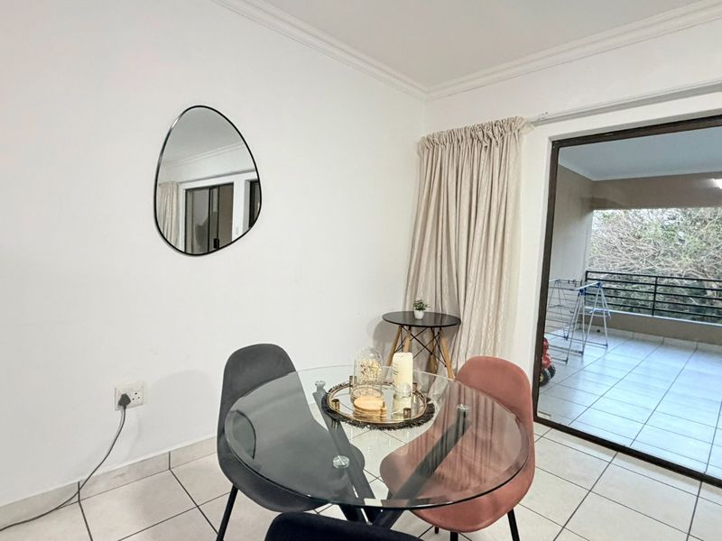 Dining area featuring tiled flooring and a large sliding glass door providing direct access to the balcony.