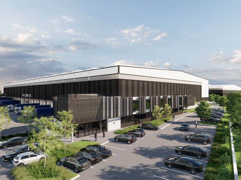 An aerial perspective of a modern industrial warehouse facility featuring extensive loading docks, dedicated parking areas, and professional landscaping.
