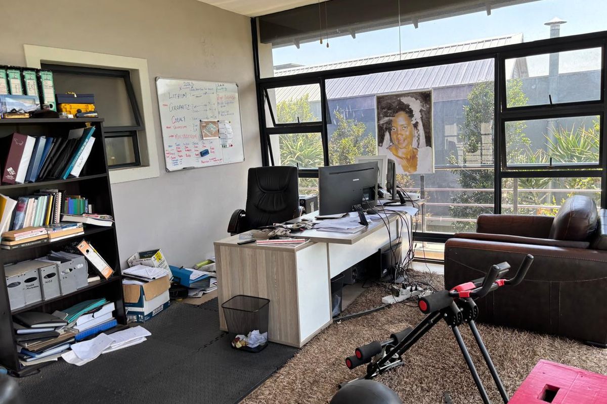 A bright home office featuring expansive aluminium-framed windows that provide ample natural light and views of the exterior.