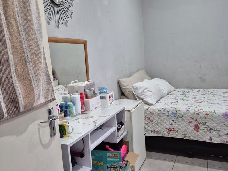 A bedroom featuring tiled flooring and neutral wall finishes, requiring minor cosmetic updates to improve the overall presentation.