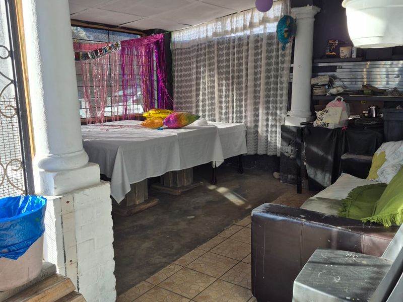A covered patio area featuring decorative columns and tiled flooring, offering a functional outdoor space for entertaining.
