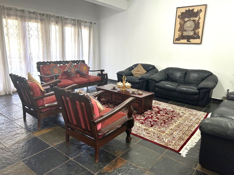 Spacious living room featuring dark slate tile flooring and large sliding glass doors that provide ample natural light.