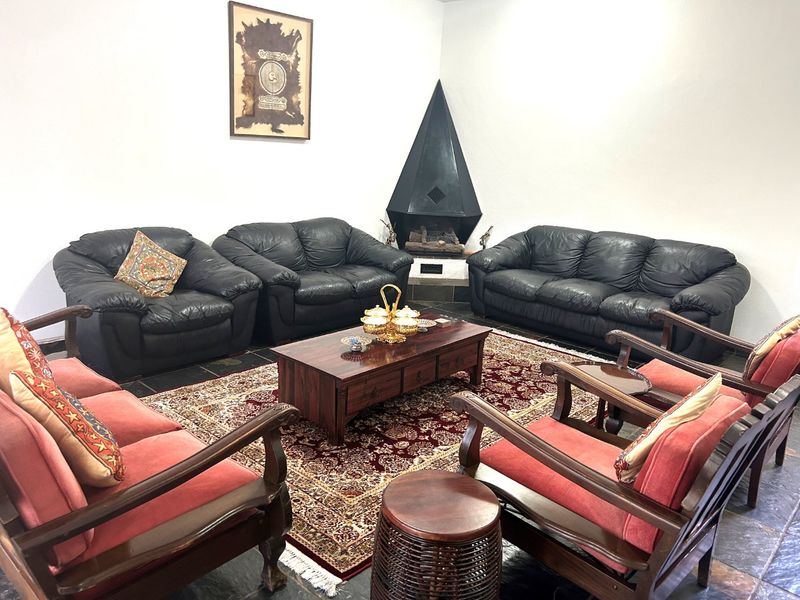 A living room featuring a distinctive black corner fireplace and dark slate tile flooring, providing a cozy and traditional atmosphere.