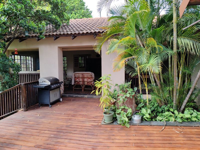A covered outdoor patio area featuring timber decking, a tiled roof, and a timber balustrade, providing a functional space for outdoor living.