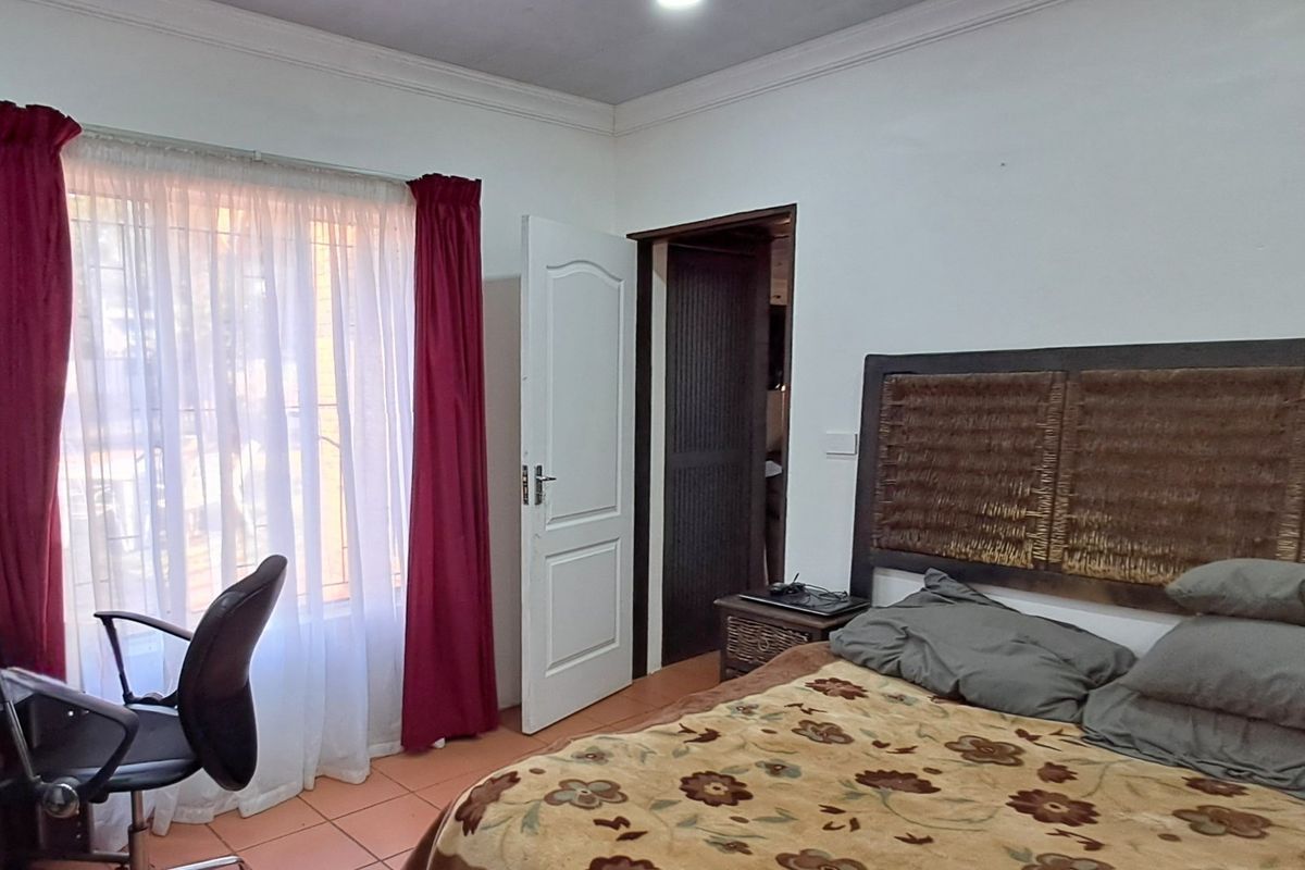 A functional bedroom featuring tiled flooring, coved ceiling details, and a standard panel door, offering a comfortable and practical living space.