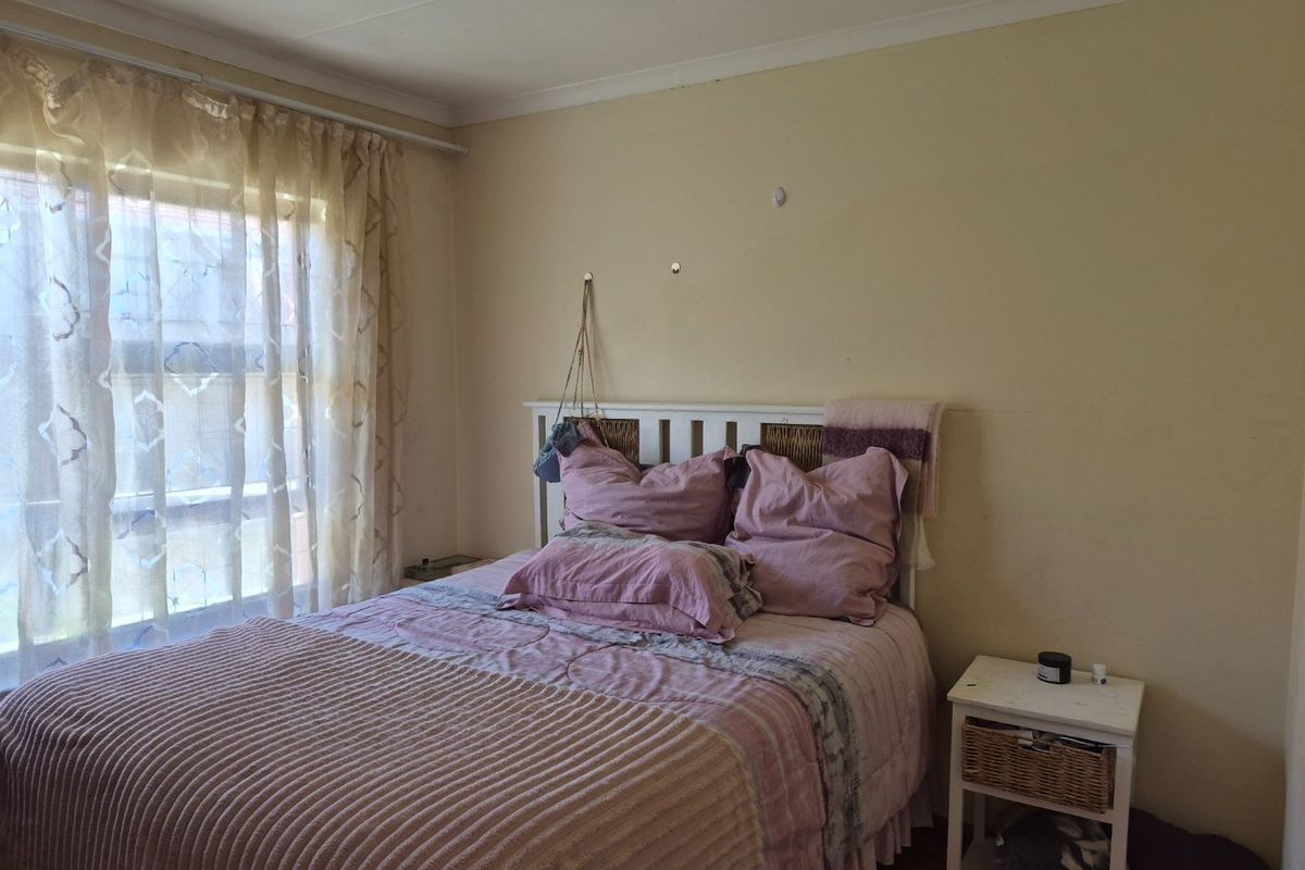 A standard bedroom featuring neutral wall finishes, coving, and a window with natural light.
