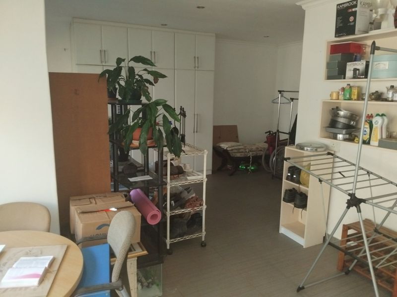 A utility or storage area featuring built-in cabinetry, recessed lighting, and tiled flooring, currently utilized for general storage.