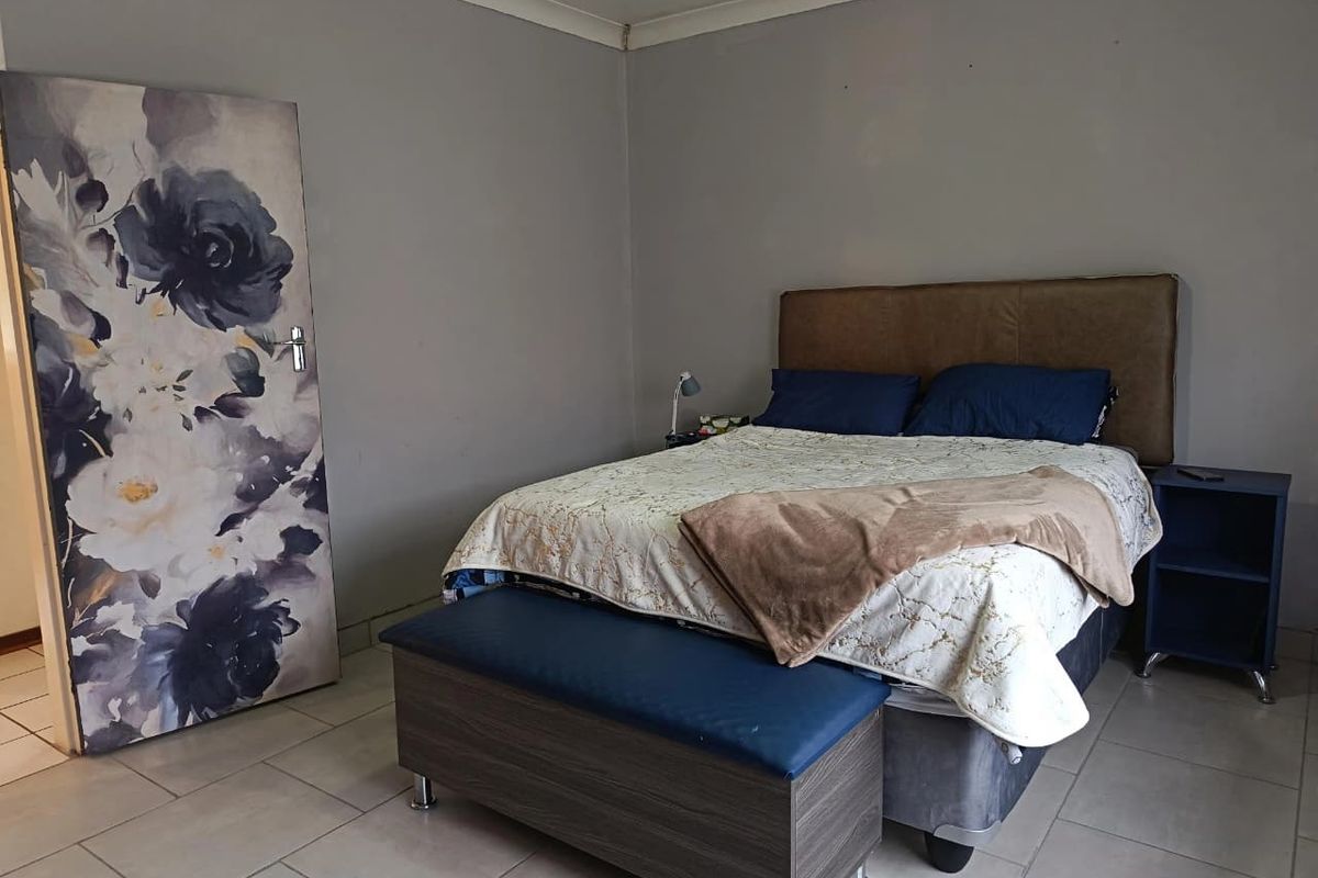 A bedroom featuring tiled flooring and neutral wall finishes, providing a functional space for rest.