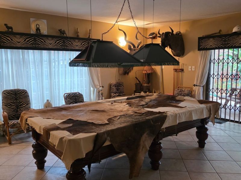 Spacious living area featuring ceramic floor tiles, large sliding glass doors with security gates, and dedicated pendant lighting over the central space.