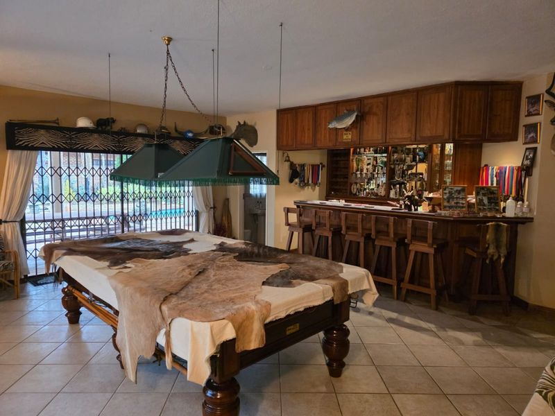A dedicated entertainment bar area featuring built-in wooden cabinetry, a bar counter, and direct access to the outdoor patio through sliding glass doors.