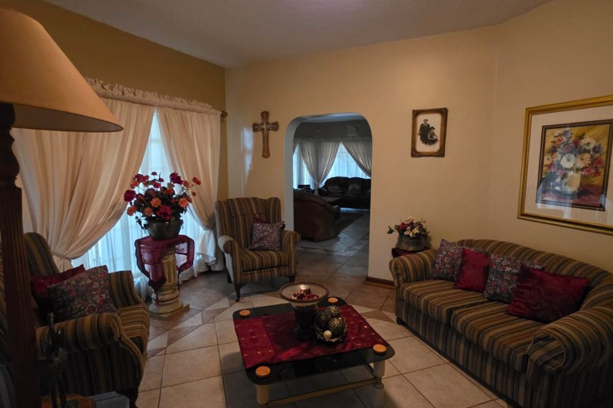 A cozy living room featuring ceramic tile flooring and an arched doorway leading to an adjacent space.