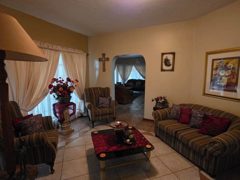 A cozy living room featuring ceramic tile flooring and an arched doorway leading to an adjacent space.