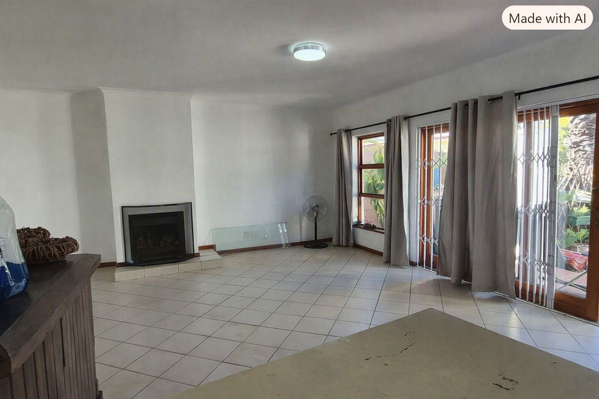 Spacious living room featuring tiled flooring, a built-in fireplace, and sliding glass doors providing access to the outdoor area.