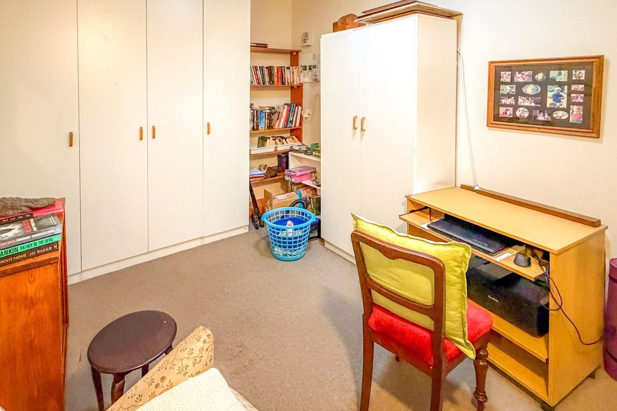 A bedroom featuring built-in wardrobes and integrated shelving, providing functional storage space within the room.