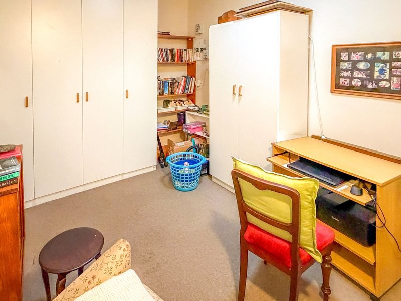 A bedroom featuring built-in wardrobes and integrated shelving, providing functional storage space within the room.