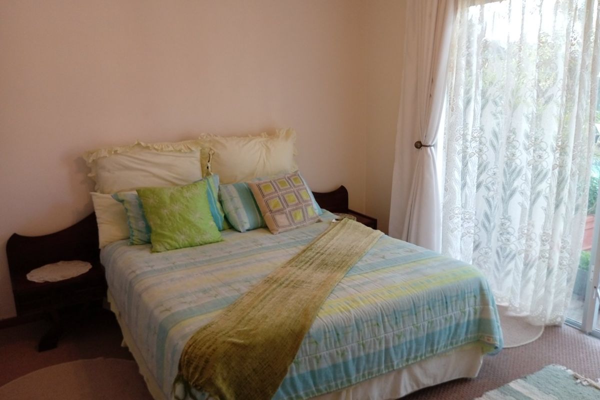 A bedroom featuring carpeted flooring and a sliding glass door providing access to the exterior.